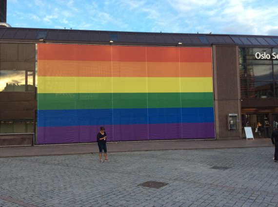 Grand drapeau de la gay pride mis sur la façade de la gare